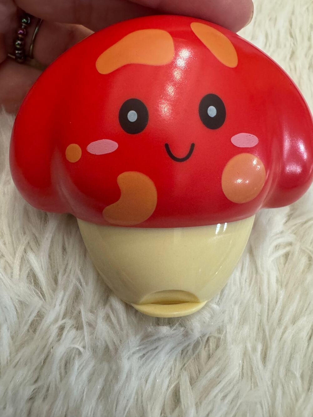 Red kawaii  mushroom with orange spots and a smiling face hand cream